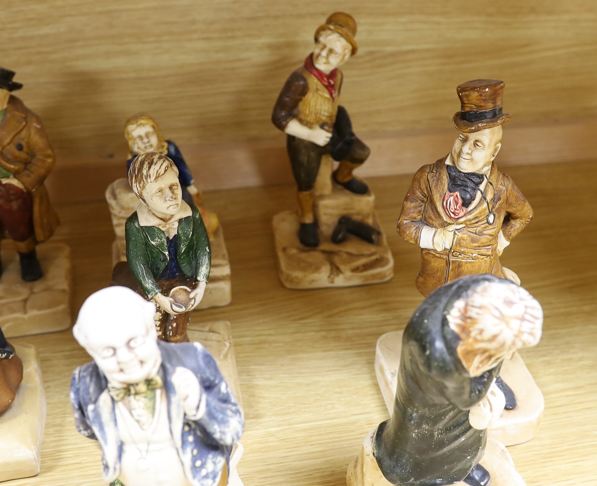 A collection of twelve Bretby cold painted pottery Dickens character figures, tallest Mr. Micawbee 25cm high